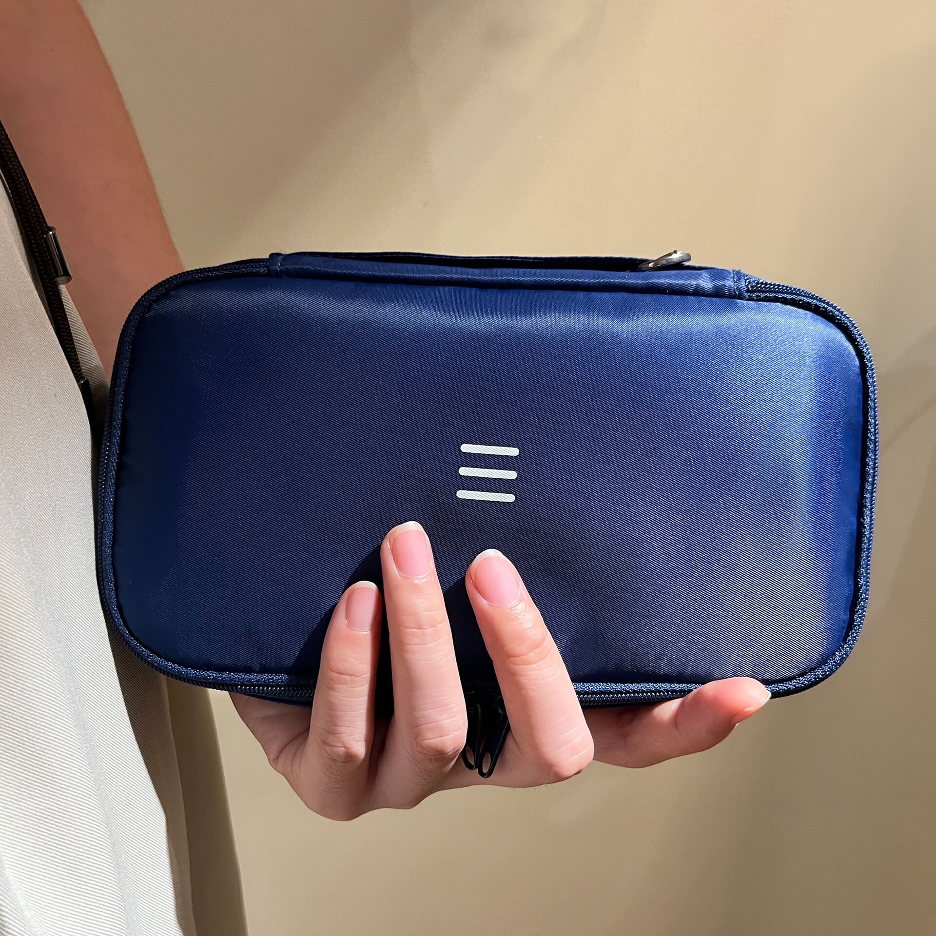 a person holding a navy 190plus organizer in hand under spotlight