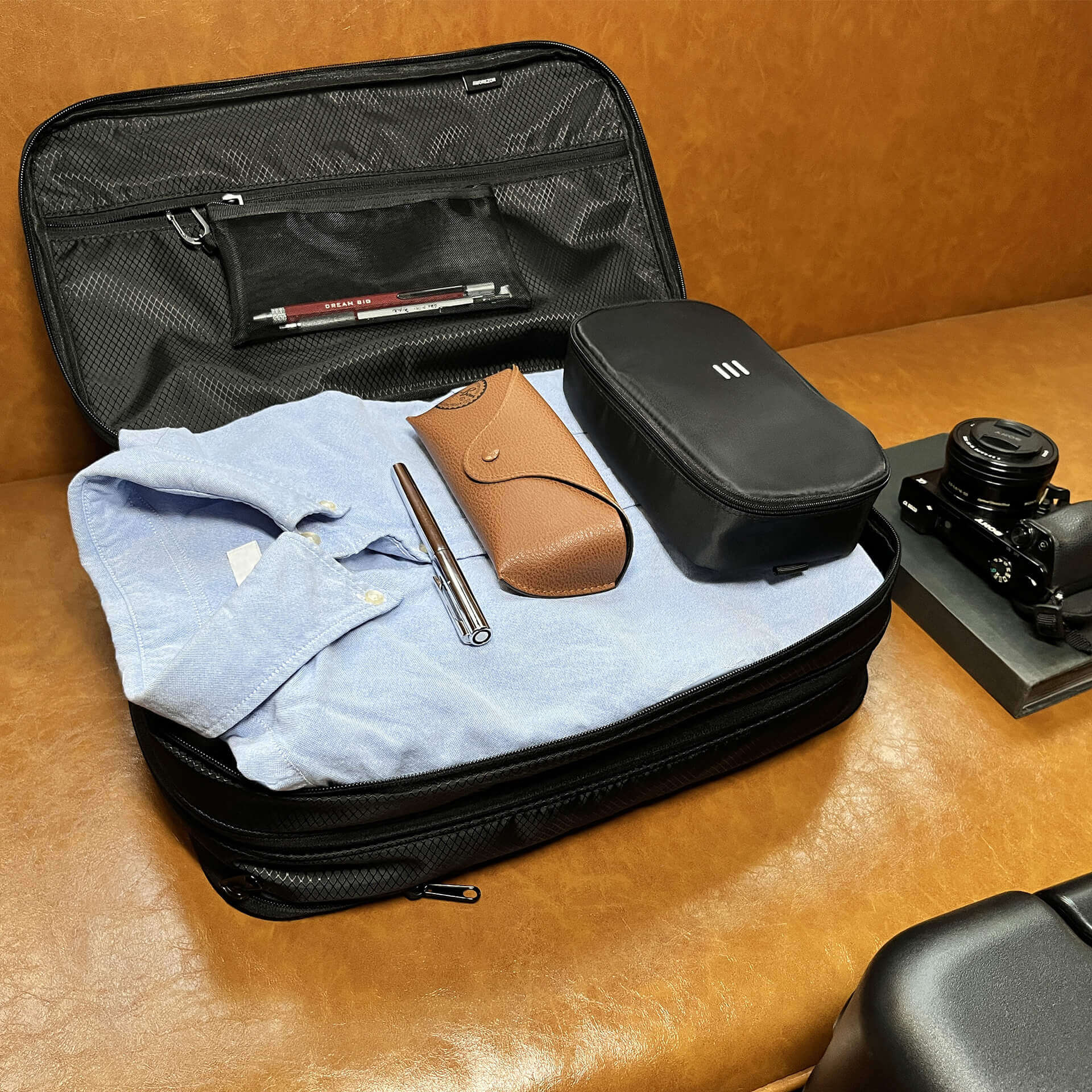 Open FLEX bag packed with clothing and a camera for a business trip