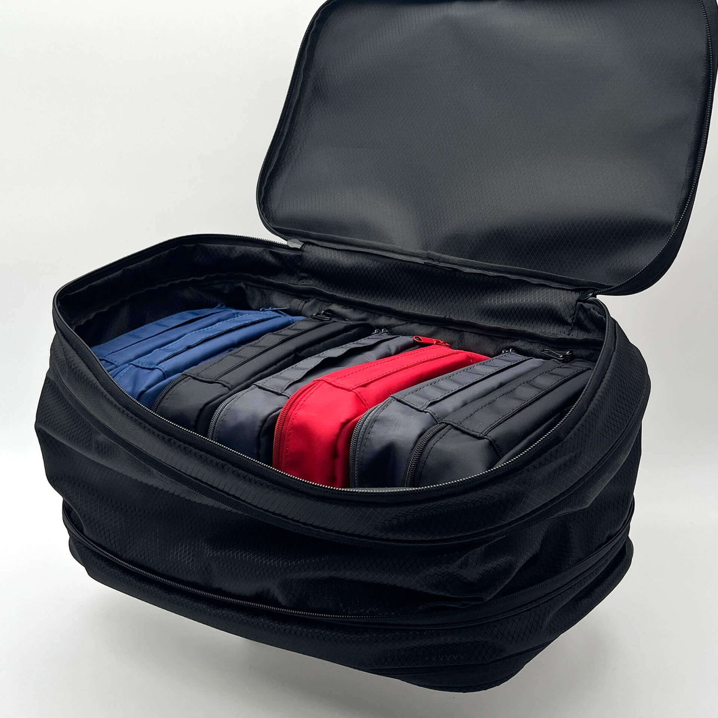 Open FLEX pouch with navy, charcoal, Onyx, and Scarlet modular organizer pouches neatly arranged inside