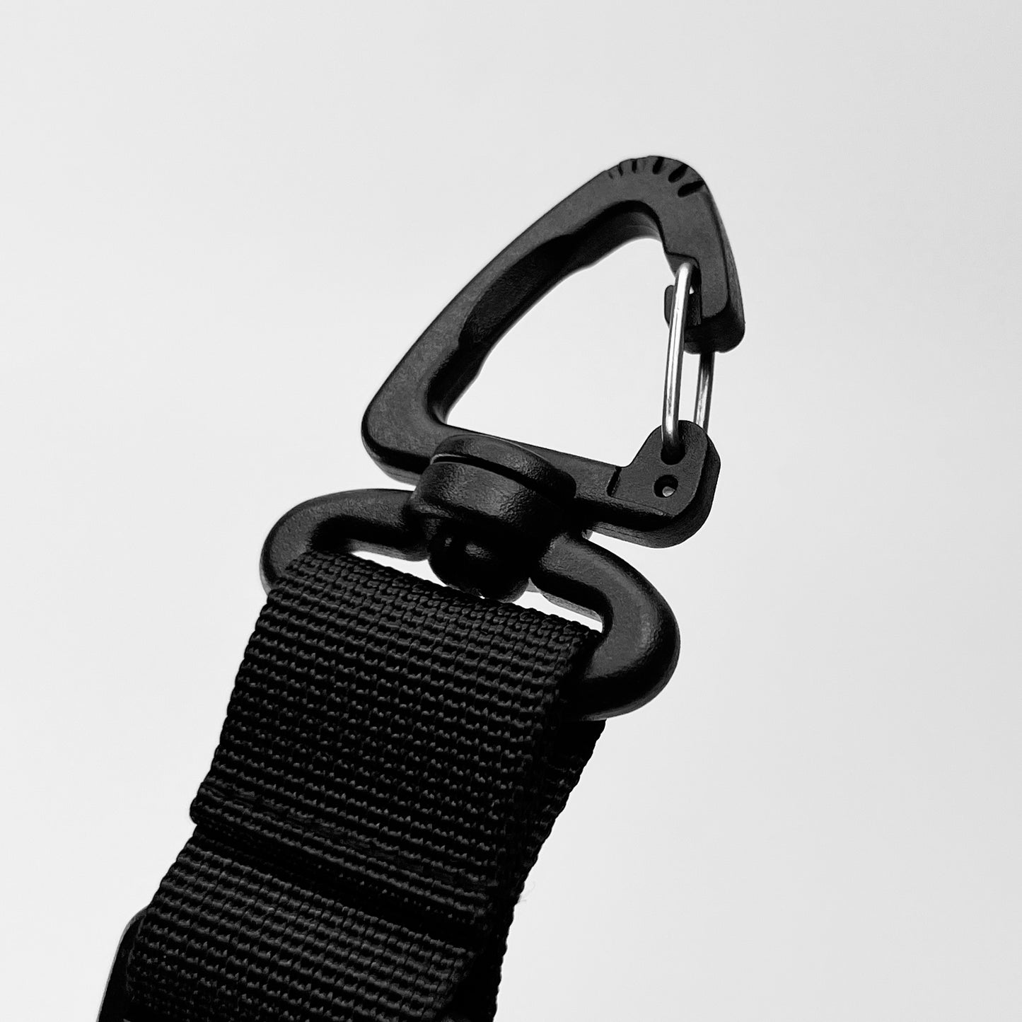 Close-up of a triangular carabiner attached to a black strap