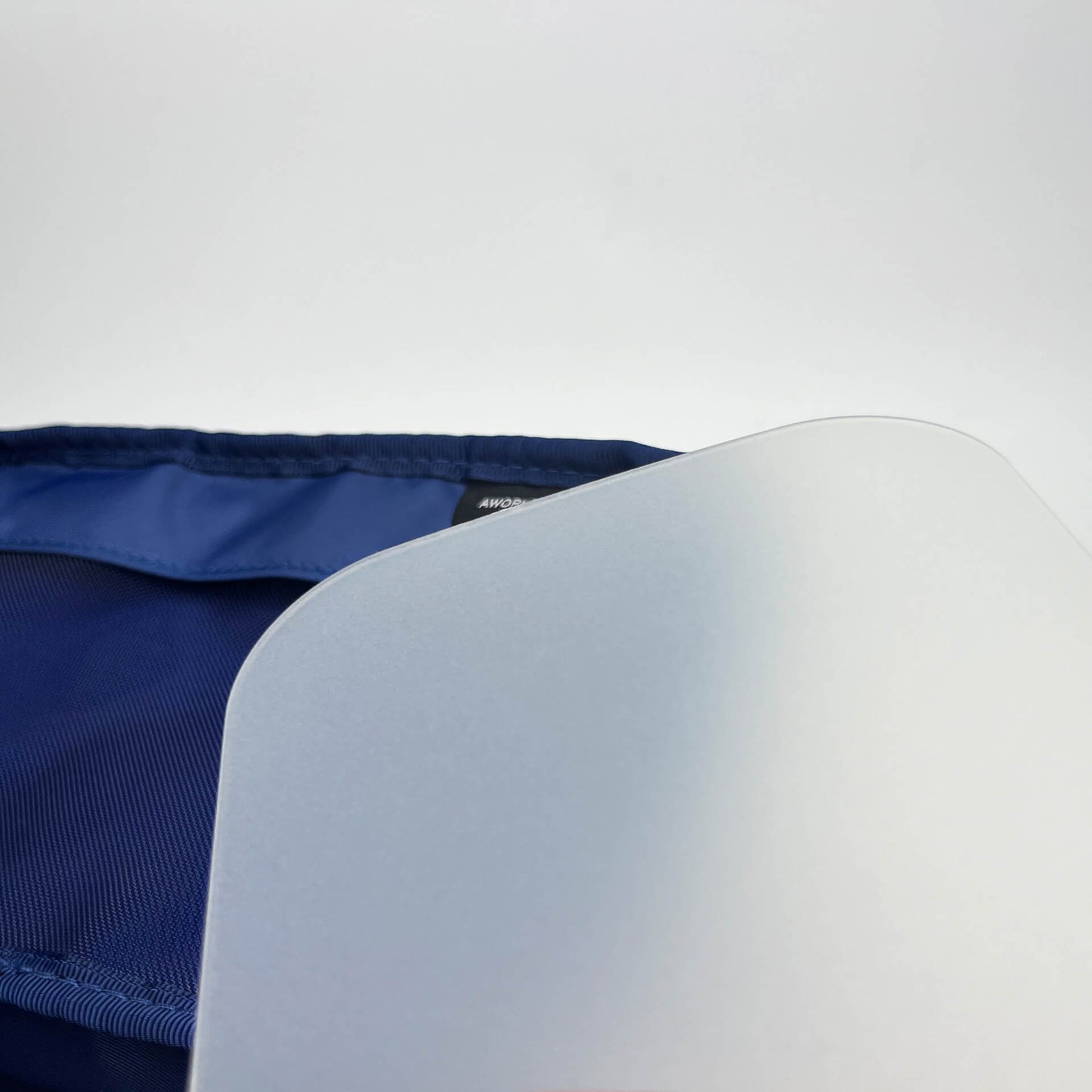 Translucent plastic plate in front of a navy organizer pouch