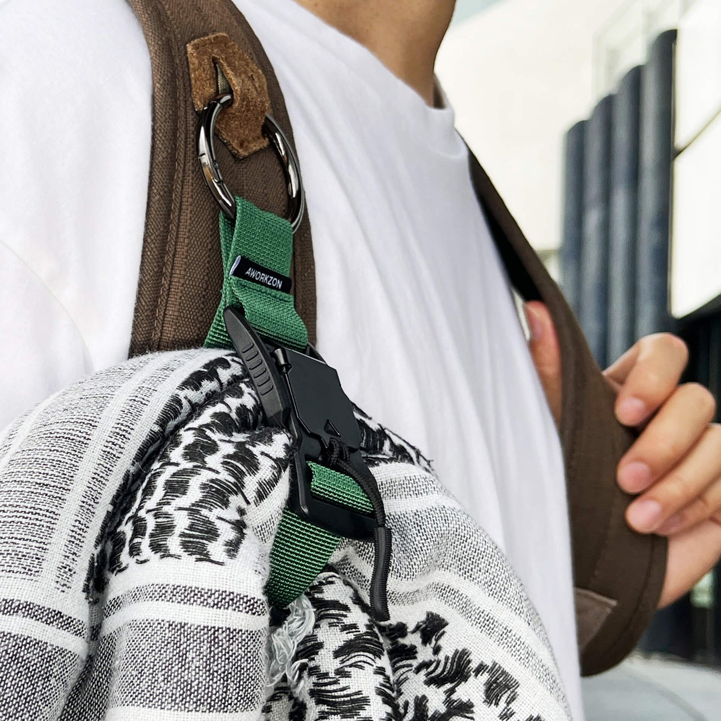 close-up green Snapal holding a scarf to a backpack