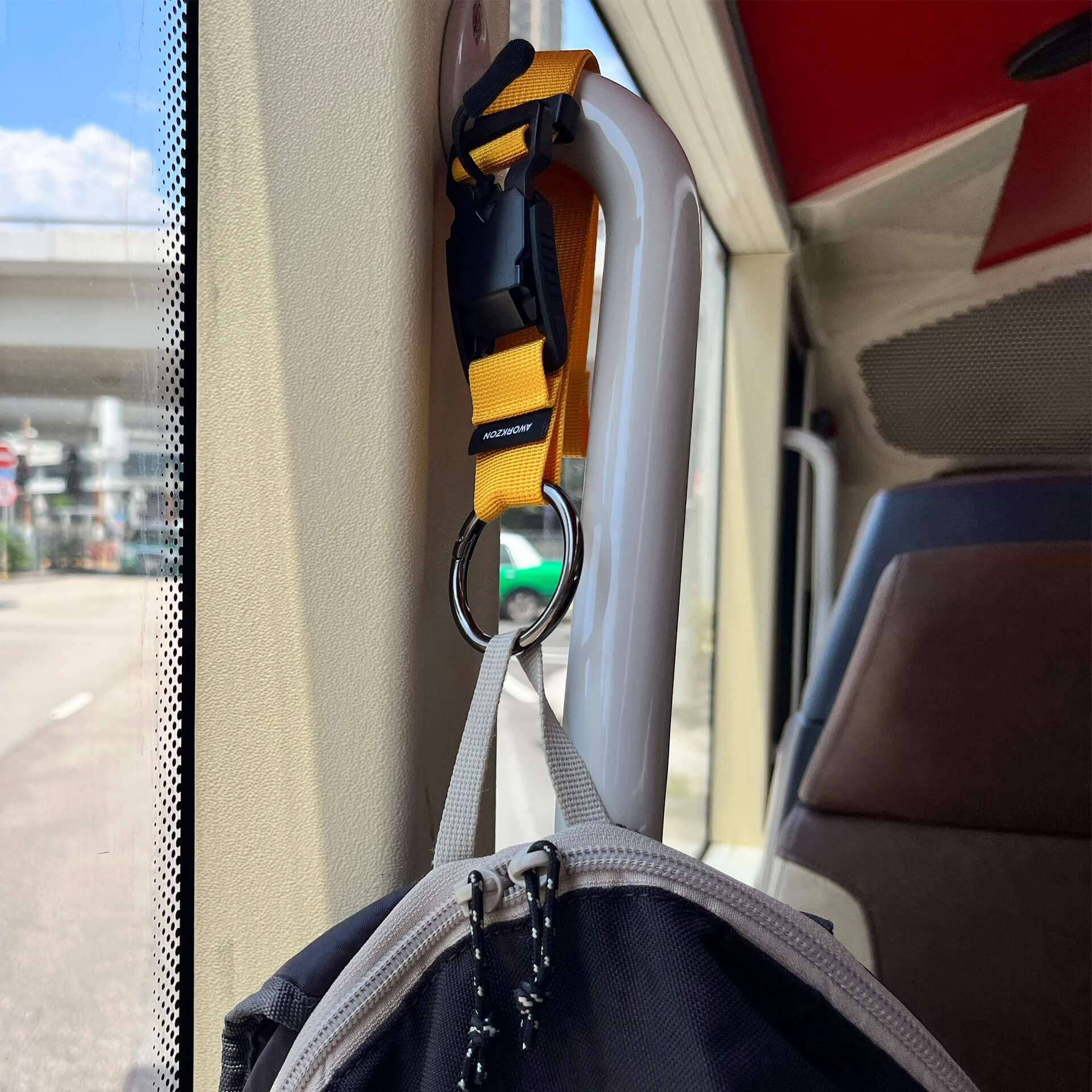 A steel O-ring spring clasp attached to a bag hanging on a vehicle's hand bar